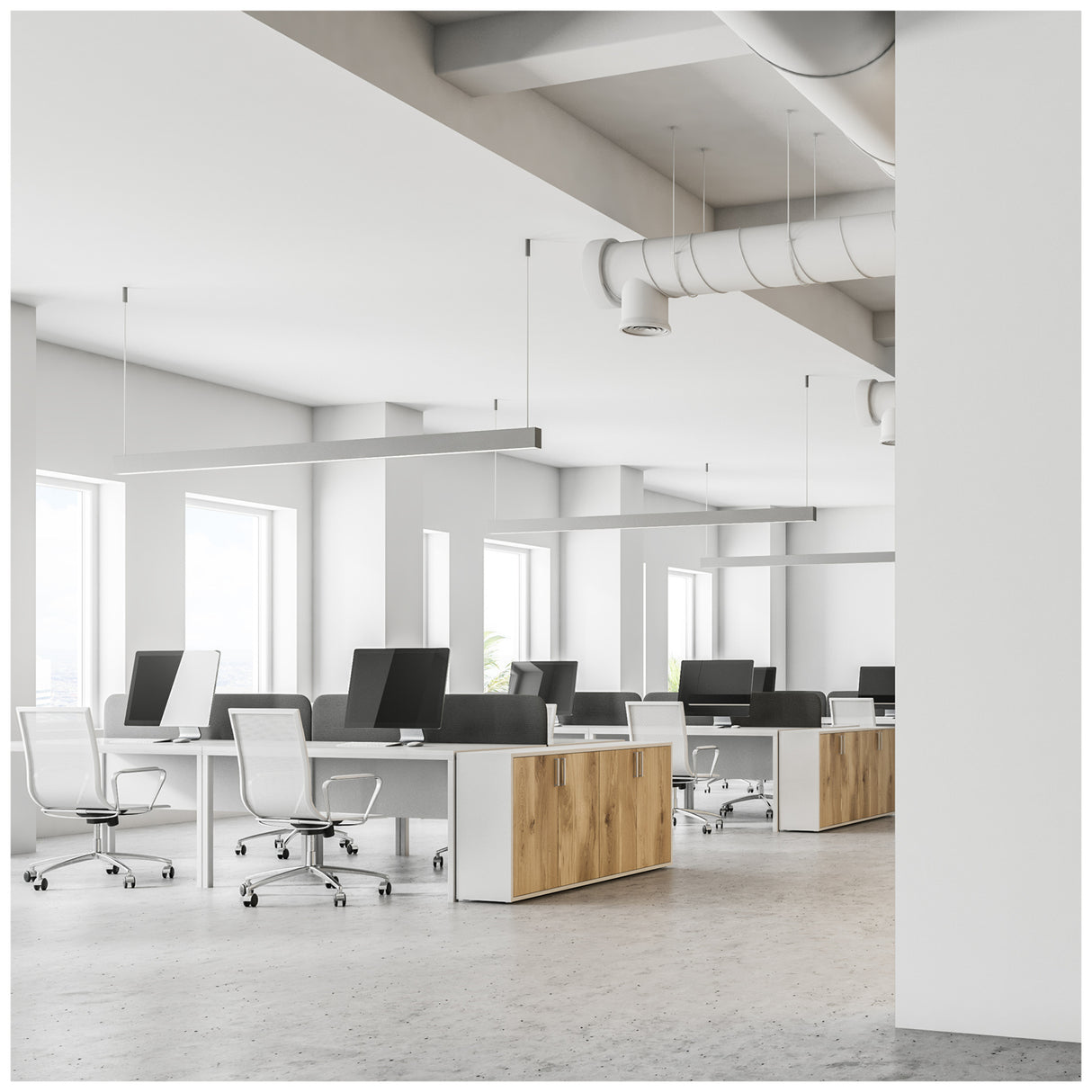 Modern open kantoorinterieur met meerdere bureaus, ergonomische bureaustoelen en grote computerschermen, gezien vanuit een schuin zijaanzicht. Heldere ruimte met veel daglicht dankzij grote ramen en minimalistische inrichting met houten accenten.