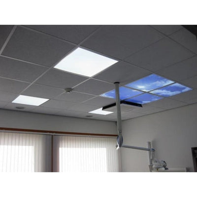 Plafondaanzicht van een systeemplafond met LED panelen, inclusief een LED paneel met blauwe lucht en wolken print, geschikt voor gebruik in onder andere tandartspraktijken of medische behandelruimtes.