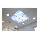Plafondaanzicht van LED plafondpanelen met wolkenprint, geïnstalleerd in een systeemplafond van een tandartspraktijk of medische behandelkamer, voor een rustgevende en sfeervolle uitstraling.